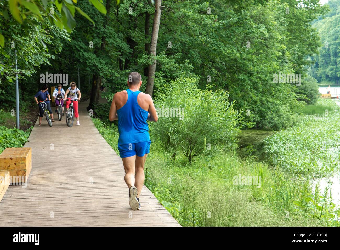Mosca, Russia - Luglio 09 2020 - Parco in città. Un uomo va per una corsa. Strada del legno Foto Stock