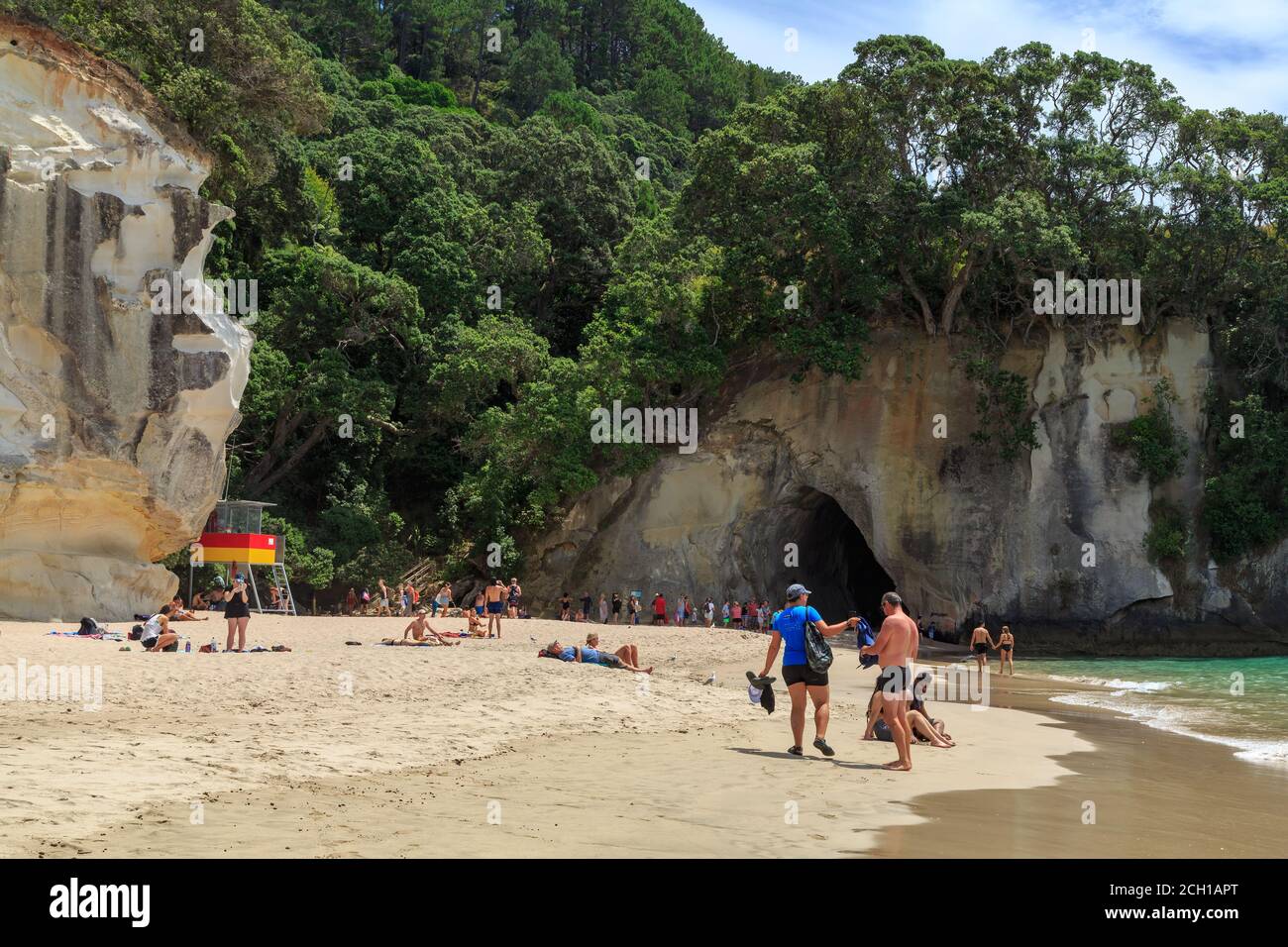 Cathedral Cove, Nuova Zelanda. Una folla di turisti sulla spiaggia di fronte al famoso arco di roccia naturale Foto Stock