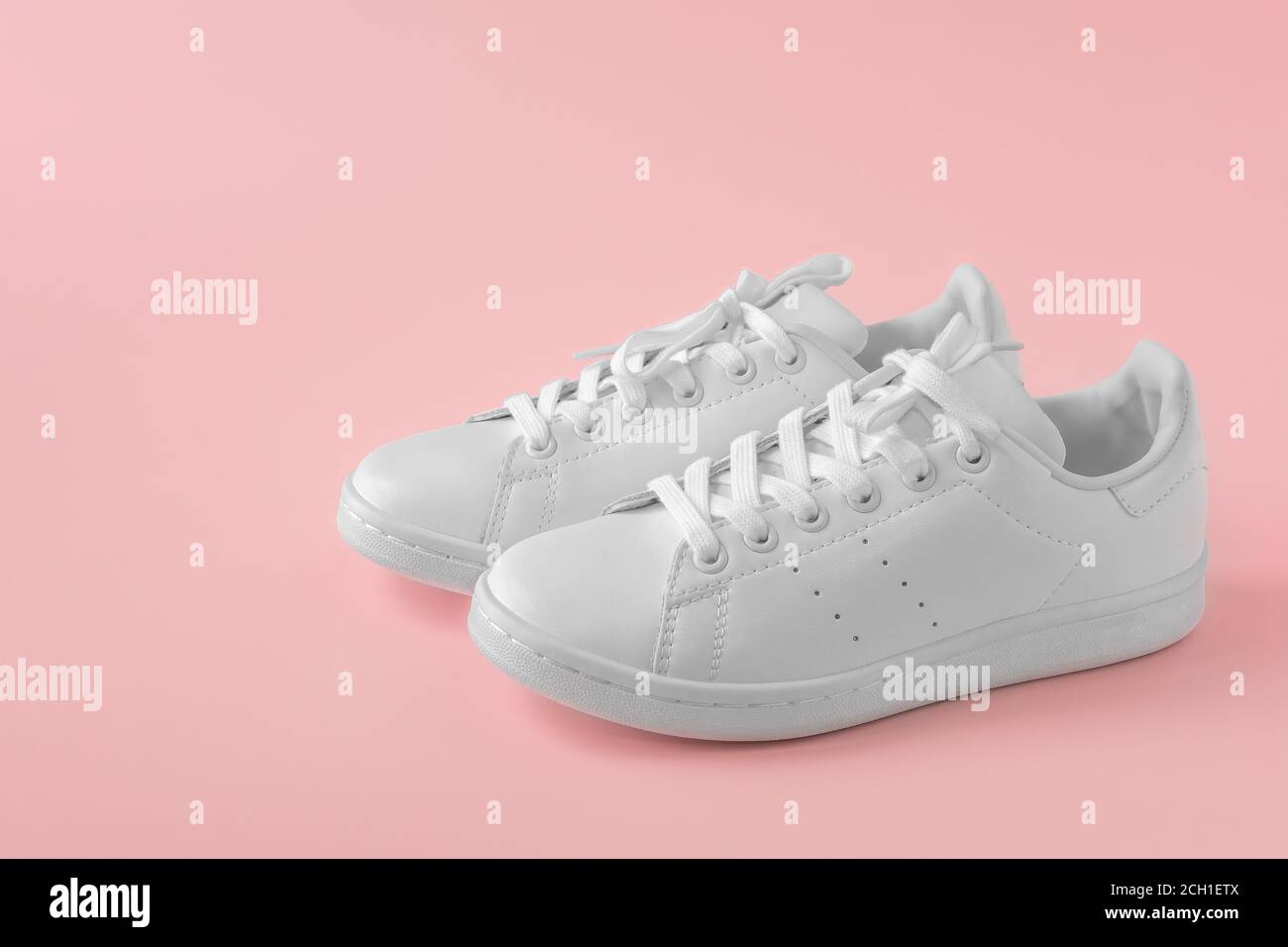 Paio di nuove eleganti sneaker bianche su sfondo rosa pastello. Nuove scarpe  sportive in pelle bianca. Scarpe sportive per running, tennis, jogging.  Copia Foto stock - Alamy