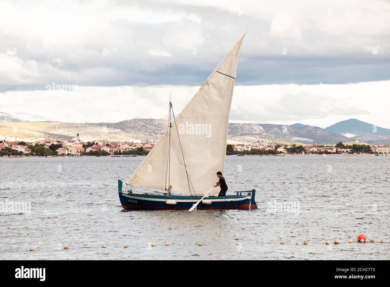 Vodice, Croazia - 1 settembre 2020: Uomo che usa una pagaia in una barca a vela Foto Stock