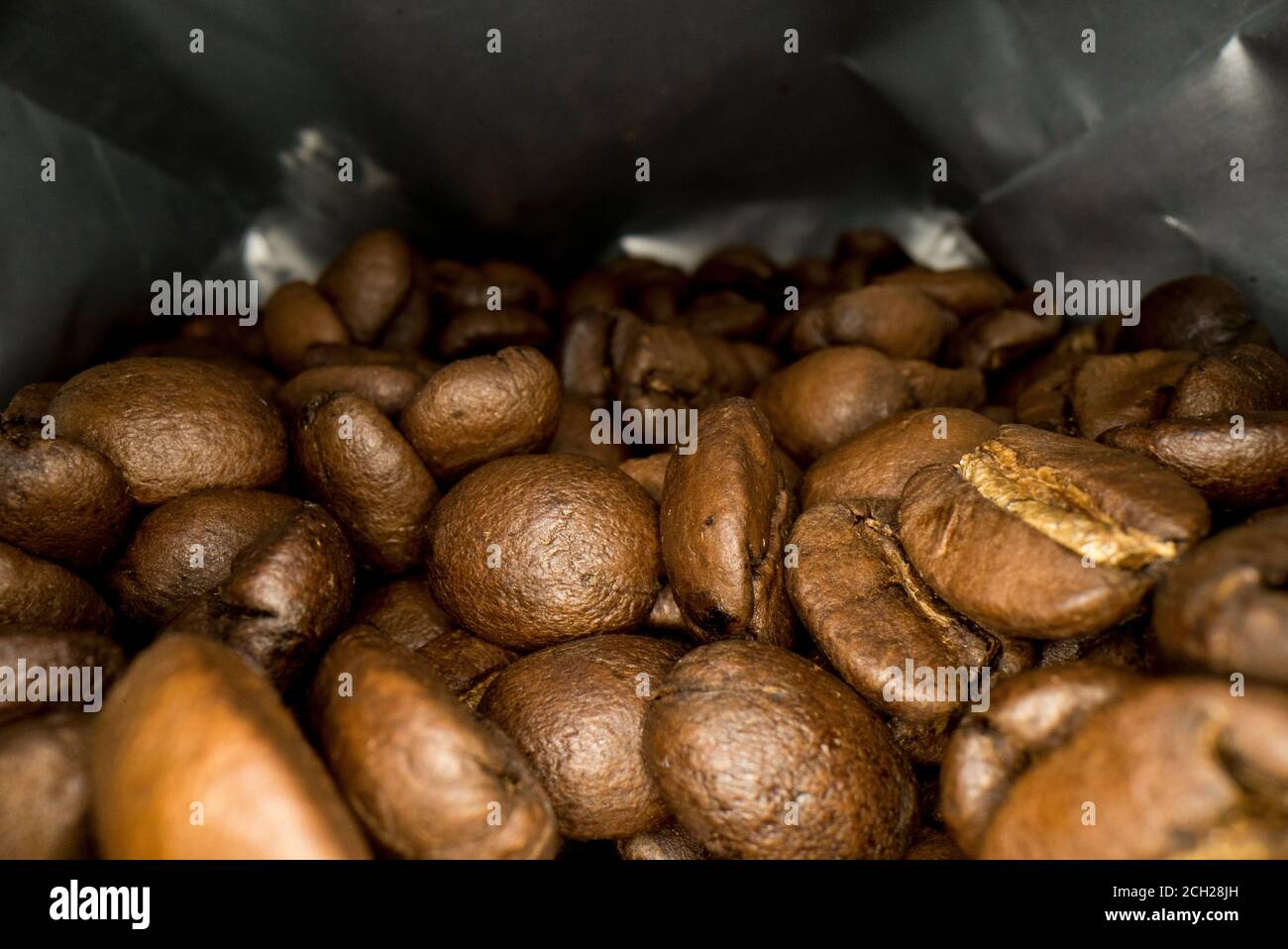 Chicchi di caffè in una confezione. Macromatura di chicchi di caffè all'interno di un sacchetto. Foto Stock