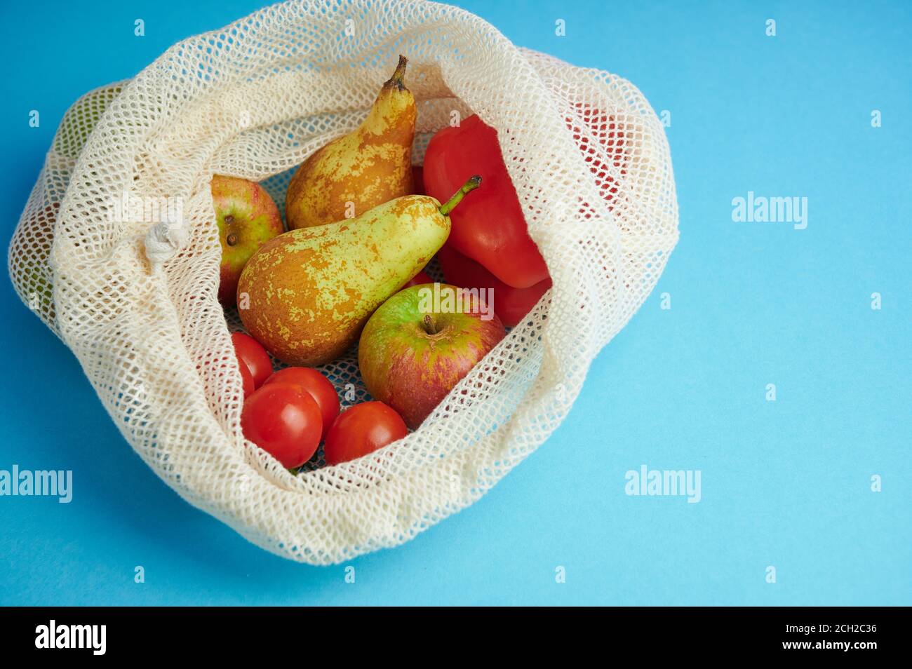 borsa in cotone per lo shopping di frutta e verdura su sfondo blu con spazio di copia, concetto per evitare sacchetti di plastica Foto Stock