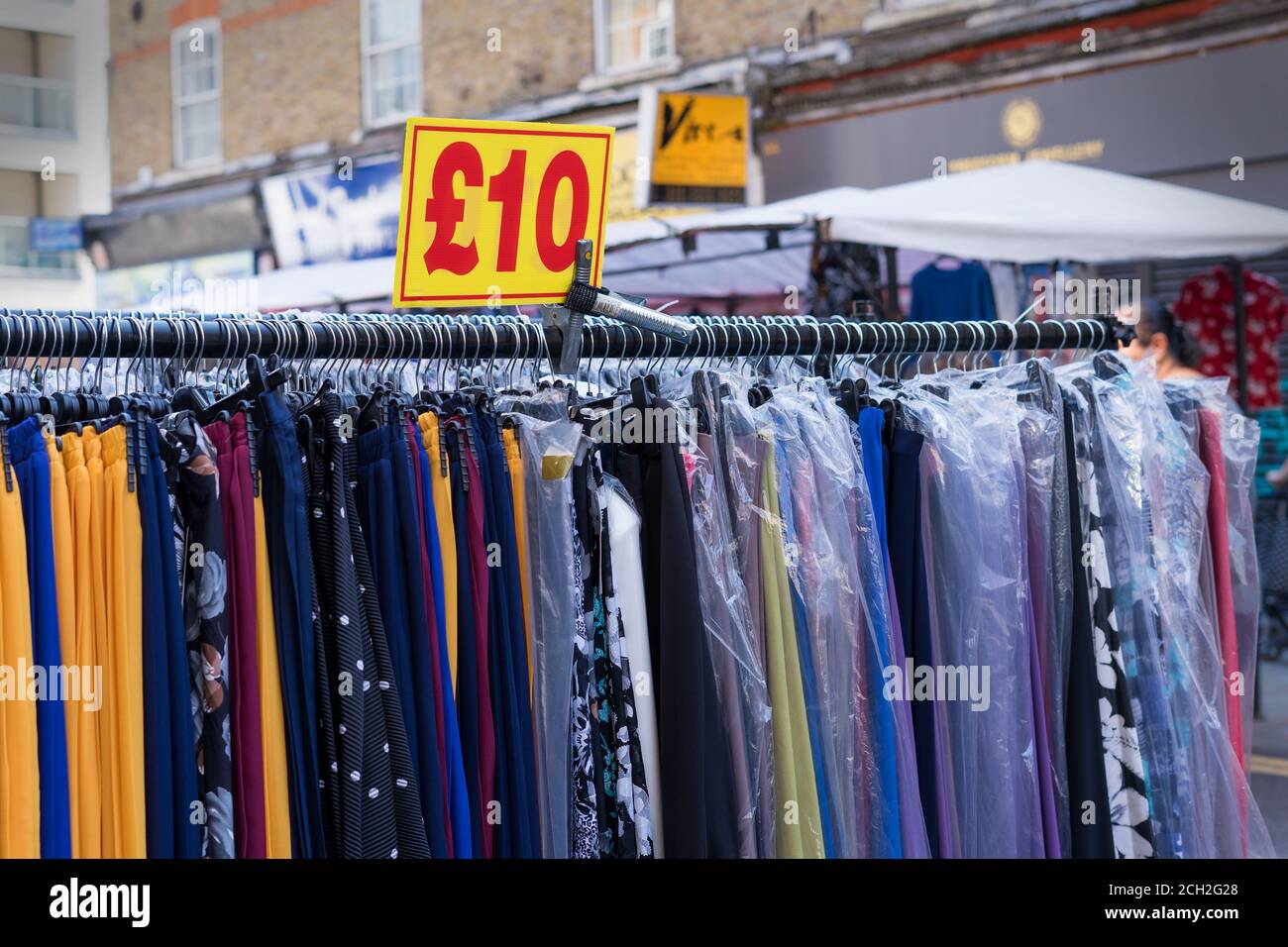 Primo piano di stalla di vestiti con un segno di prezzo giallo. Petticoat Lane Market. Londra Foto Stock