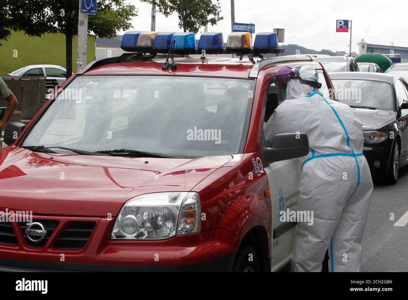A Coruna-Spagna -18 agosto 2020: Un operatore sanitario utilizza un test PCR (bocca e tampone nasale) su una persona all'interno di un'auto un fiffirefighter Foto Stock