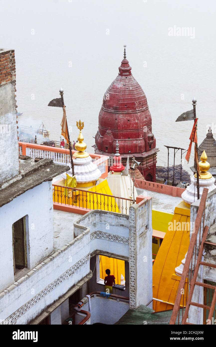 Varanasi, Uttar Pradesh, India : UN giovane brahmin guarda dalla finestra di una scuola di vedic al tempio di Baba Mashan Nath a Manikarnika ghat. Foto Stock