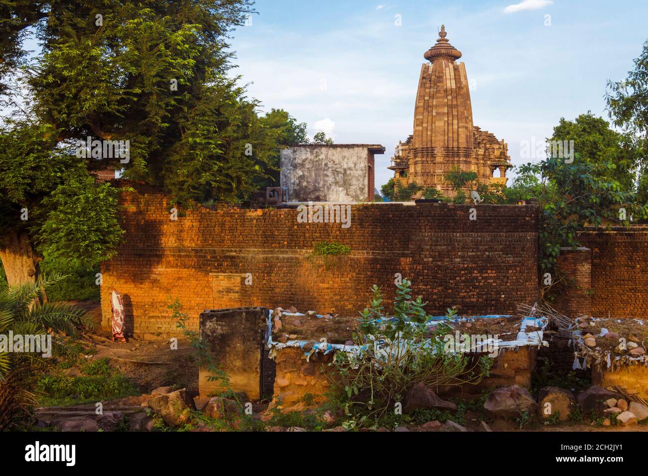 Khajuraho, Madhya Pradesh, India : una donna indiana cammina nella campagna intorno al Tempio di Vamana parte del gruppo orientale del mondo UNESCO lei Foto Stock