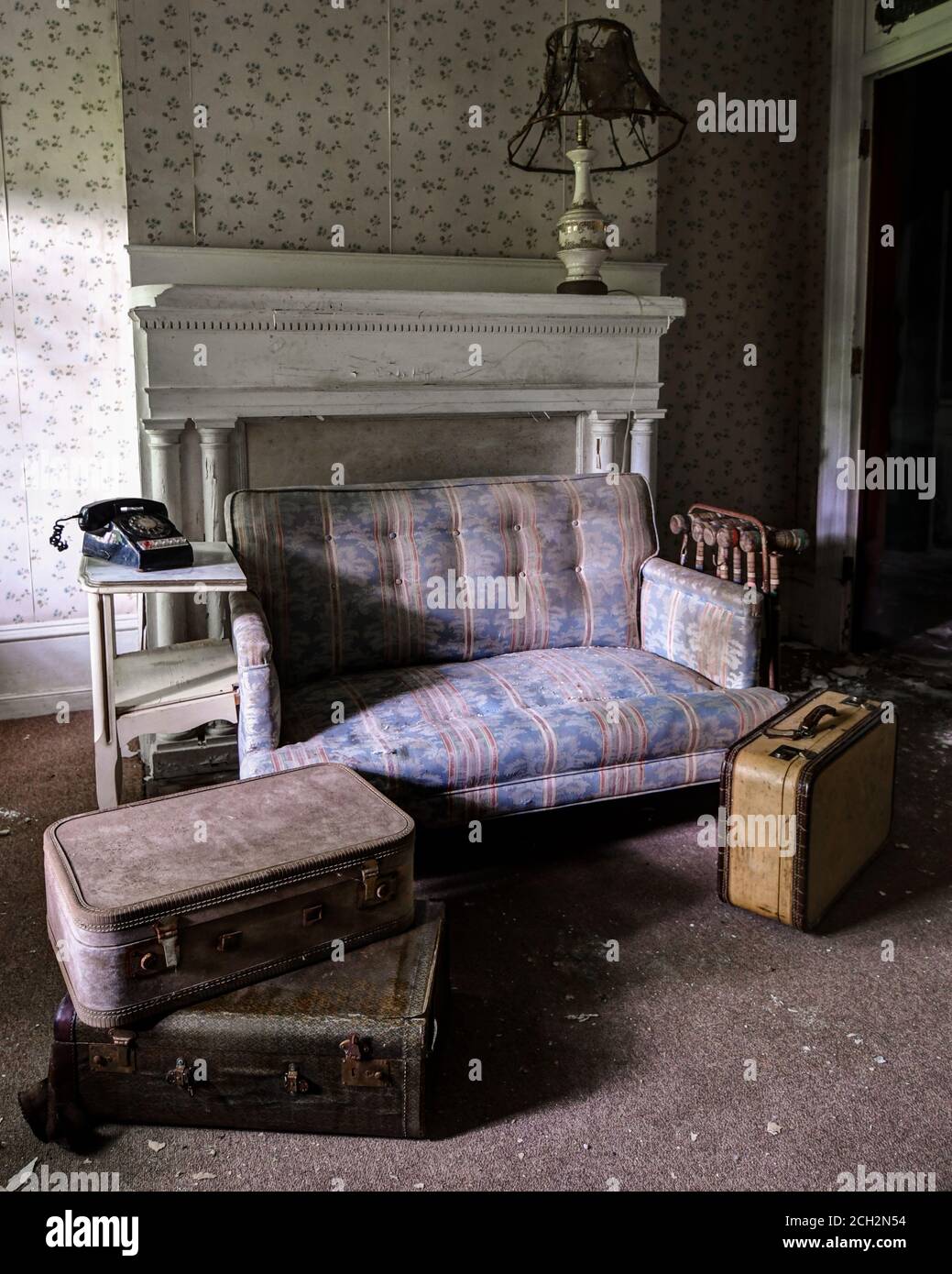 casa abbandonata con divani e valigie Foto Stock