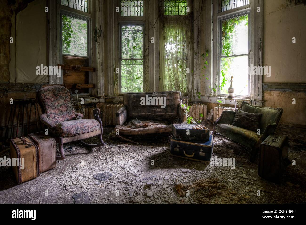casa abbandonata con divani e valigie Foto Stock