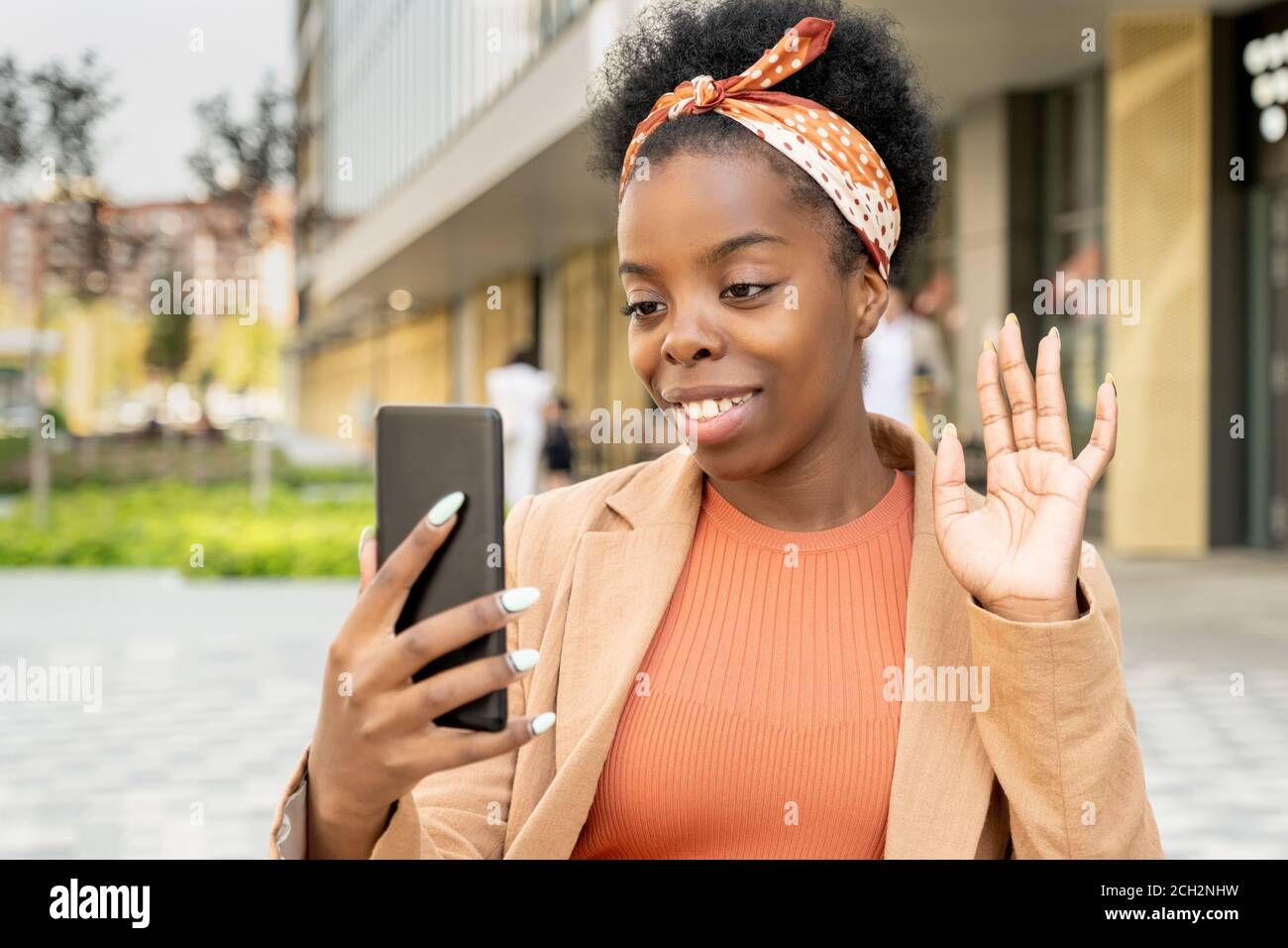 Giovane donna di etnia africana che guarda il suo amico sopra display dello smartphone Foto Stock