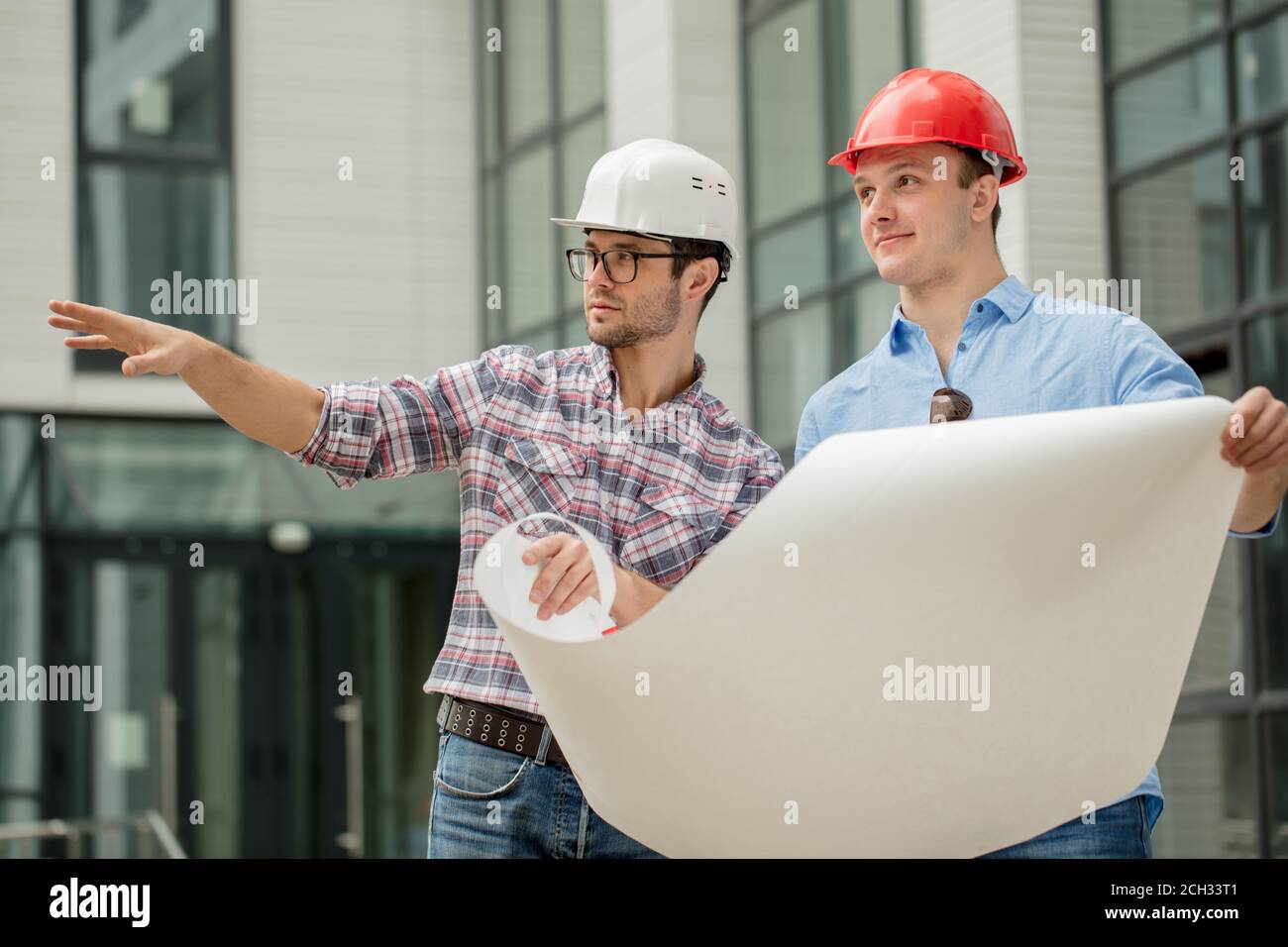 due costruttori stanno per demolire il vecchio edificio. primo piano ritratto. occupazione concetto Foto Stock