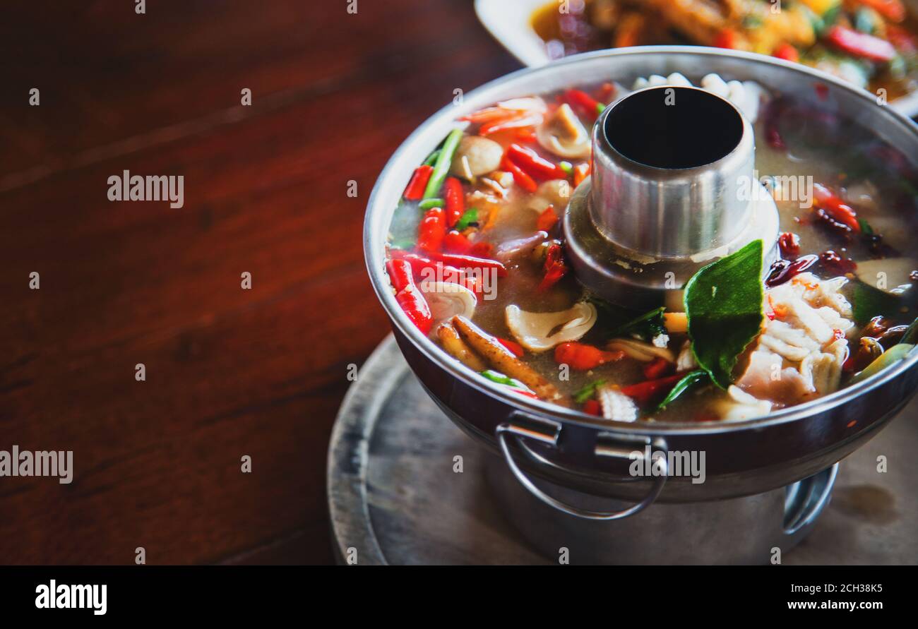 Zuppa piccante di cibo tailandese con peperoncino, foglia di bergamott, zenzero, funghi e altre erbe per il buon cibo salutare chiamare 'Tomyum'. Sercve con pentola di ferro caldo per kee Foto Stock