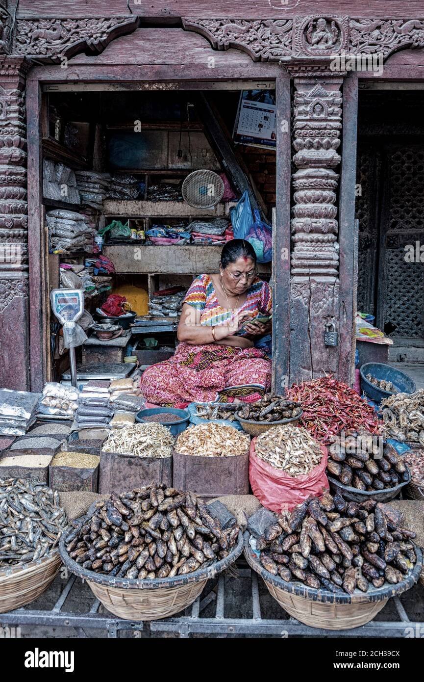 KATHMANDU, NEPAL - 14 AGOSTO 2018: Donna nepalese non identificata siede il suo negozio nella strada di Kathmandu, Nepal Foto Stock