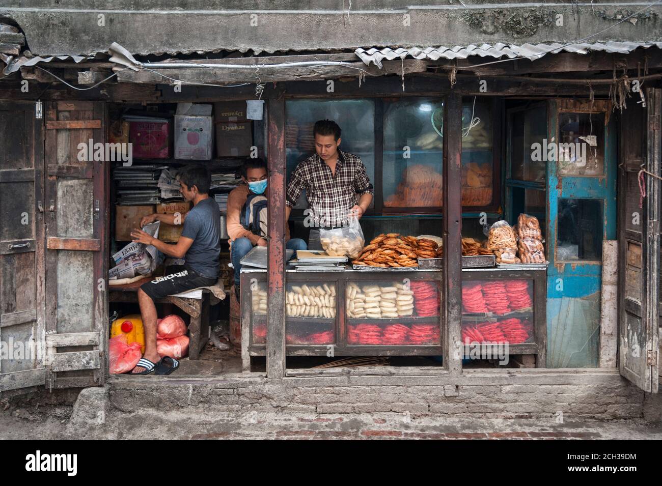 KATHMANDU, NEPAL - 14 AGOSTO 2018: Uomini nepalesi non identificati che vendono alimenti in un negozio nella strada di Kathmandu, Nepal Foto Stock