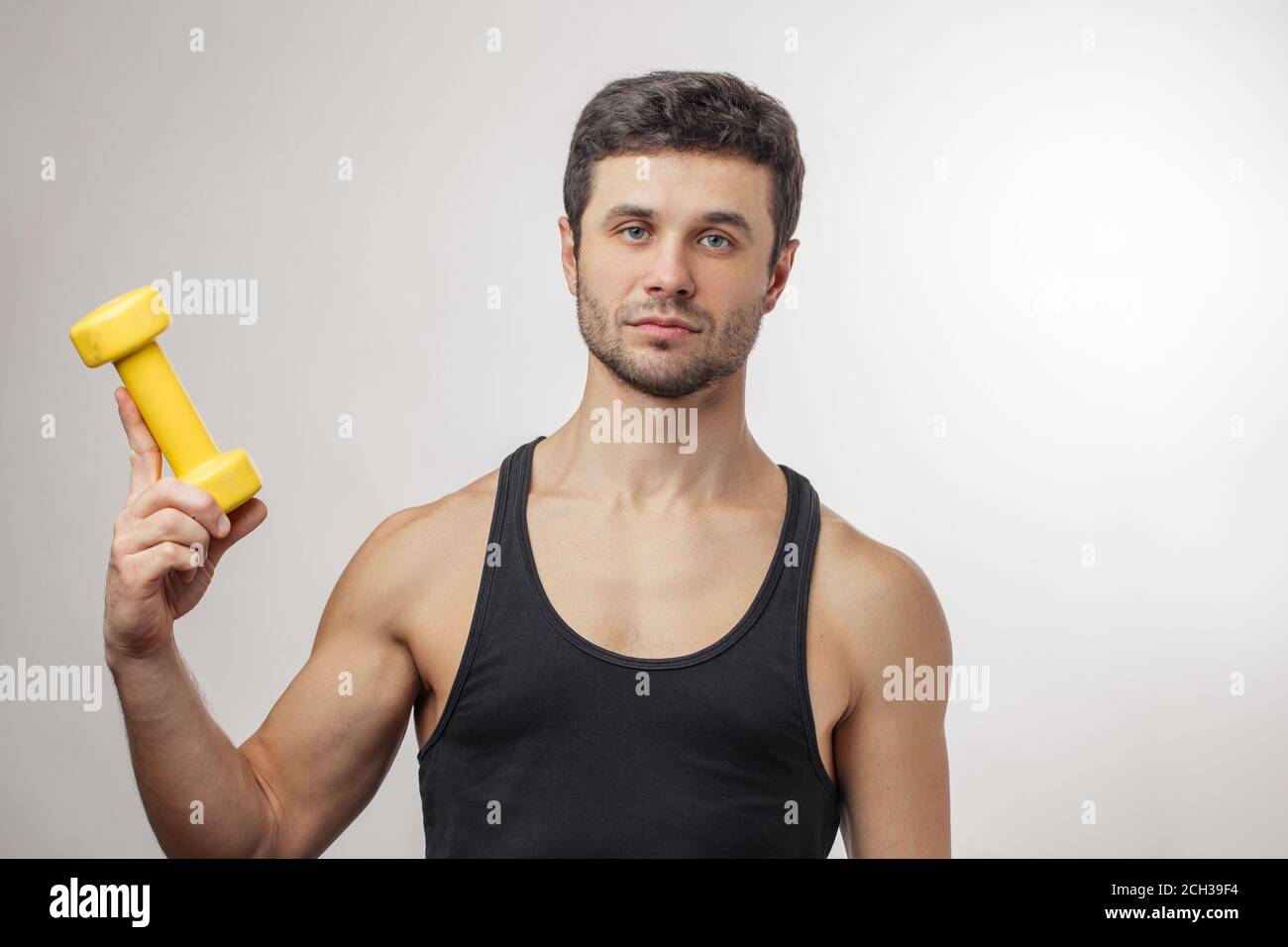 uomo serio che tiene in mano gli attrezzi sportivi Foto Stock