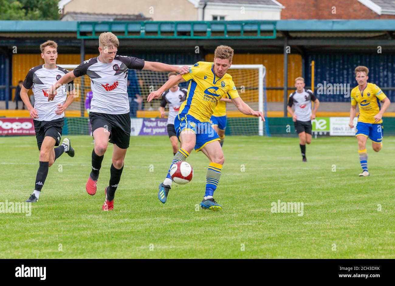 Jack Mackreth di Warrington Town AFC controlla la palla dentro Davanti ai giocatori della U23 di Salford City Foto Stock
