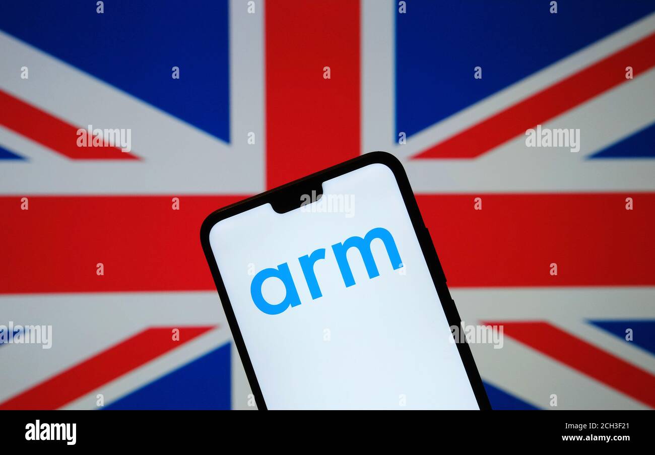 Logo ARM Holdings visto sulla silhouette della stiva per smartphone In mano e la bandiera del Regno Unito su un offuscato sfondo Foto Stock