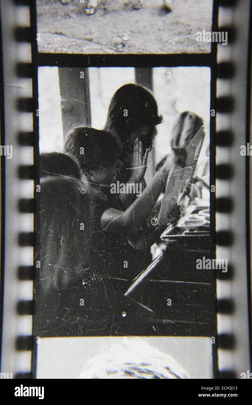 Bella fotografia in bianco e nero degli anni '70 di un'ombra di una truppa scout che fa servizio in cucina mentre si accampano al campo scout. Foto Stock