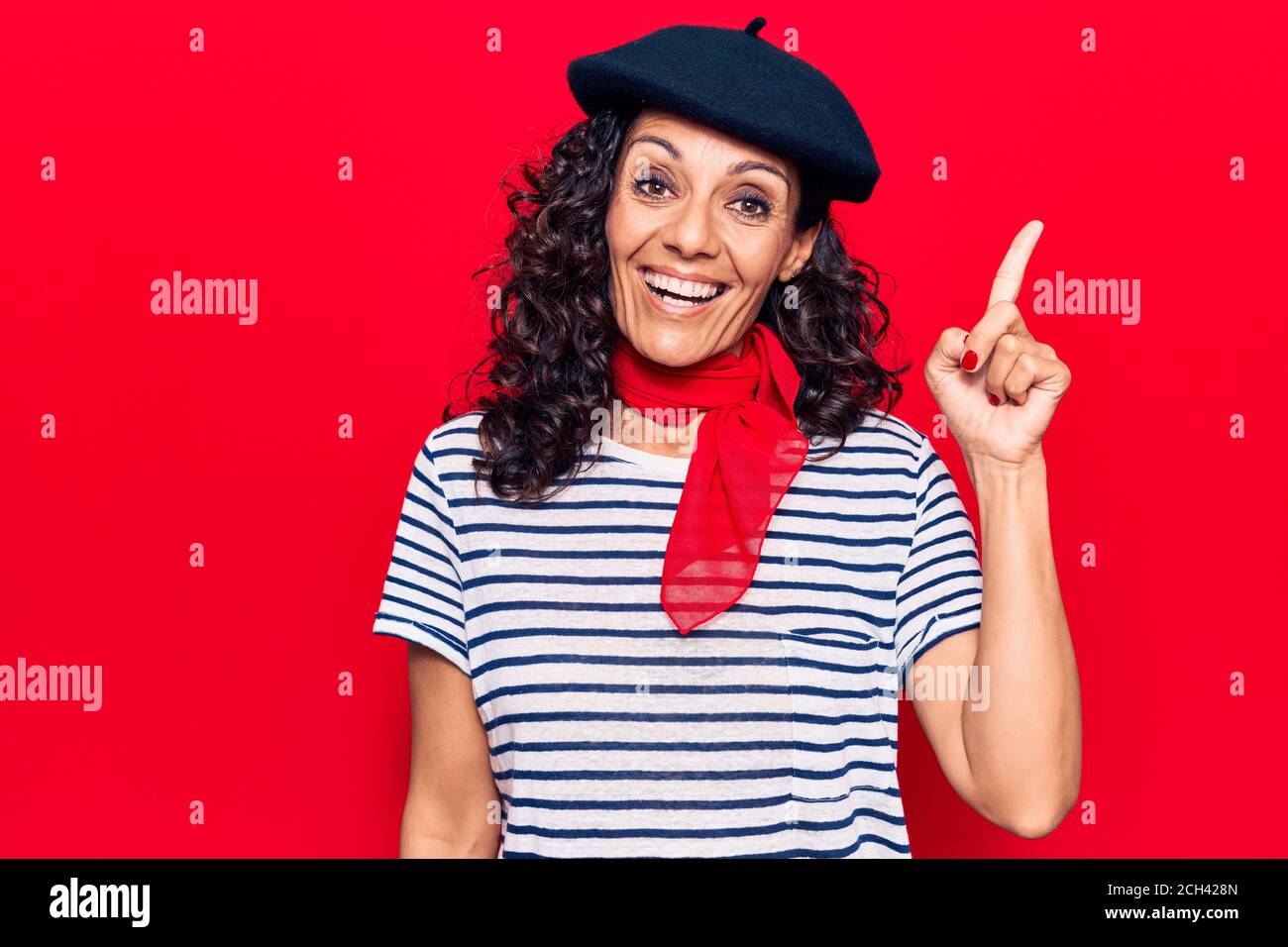 Di mezza età bella donna che indossa beretto francese sorridente con un'idea o una domanda che punta il dito verso l'alto con il volto felice, numero uno Foto Stock