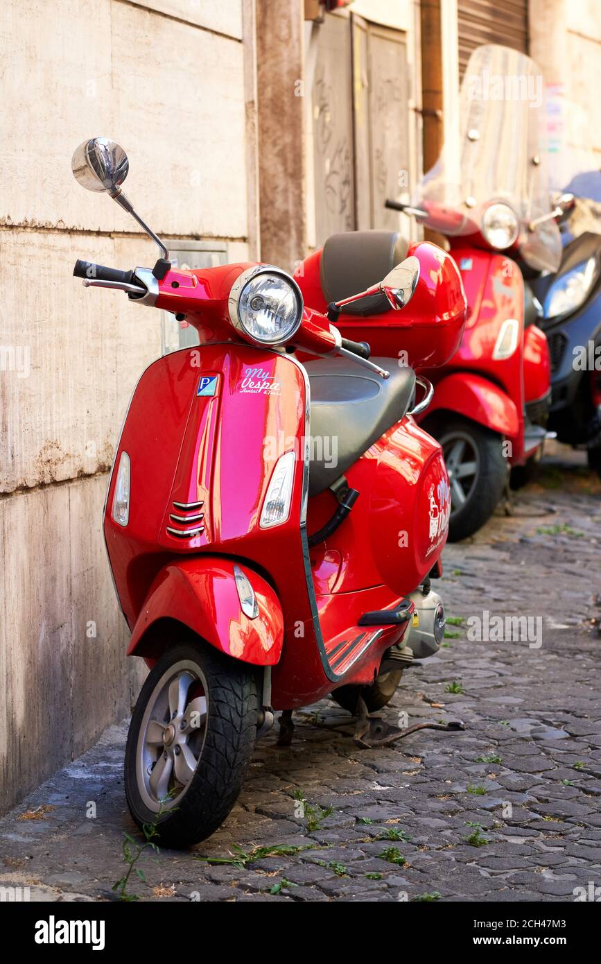 Roma, Italia: Due scooter Red Vespa parcheggiati in una tipica strada  romana nel centro della città Foto stock - Alamy