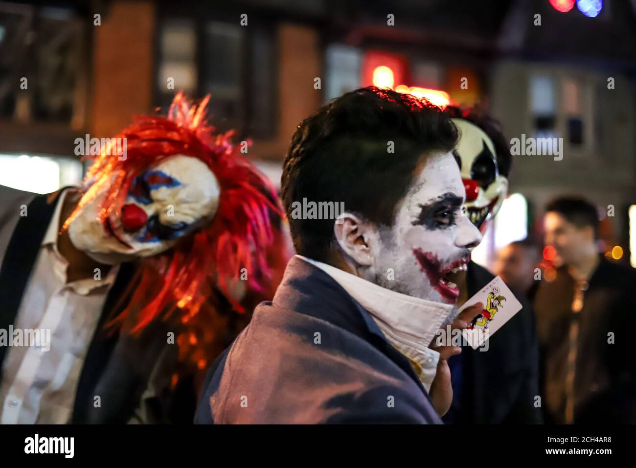 Halloween notte carnevale . Chiesa strada, persone che camminano in maschere e costumi diversi. Foto Stock