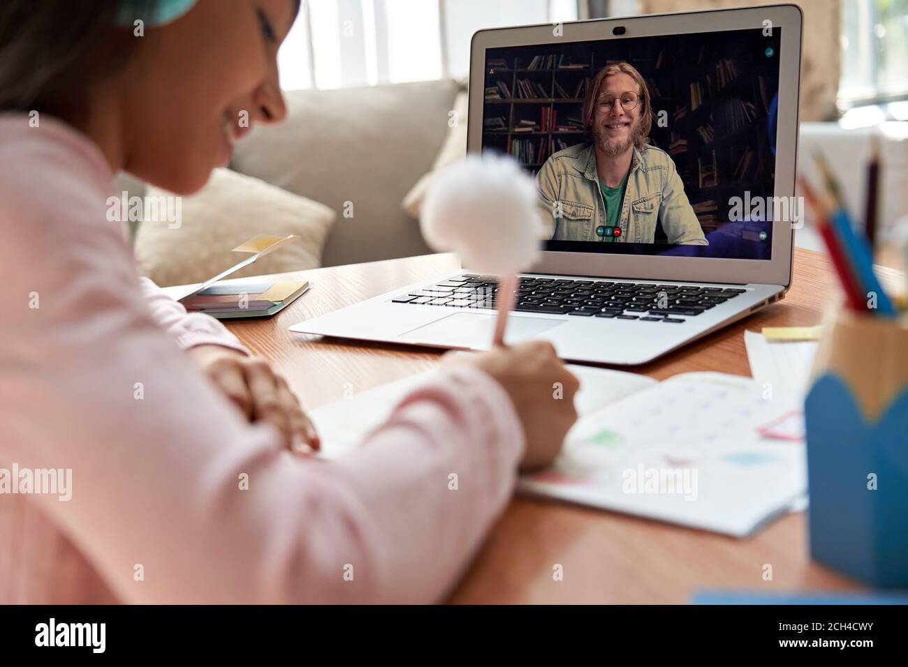 Insegnante online sullo schermo del computer portatile che dà una classe di zoom remoto per la ragazza della scuola. Foto Stock
