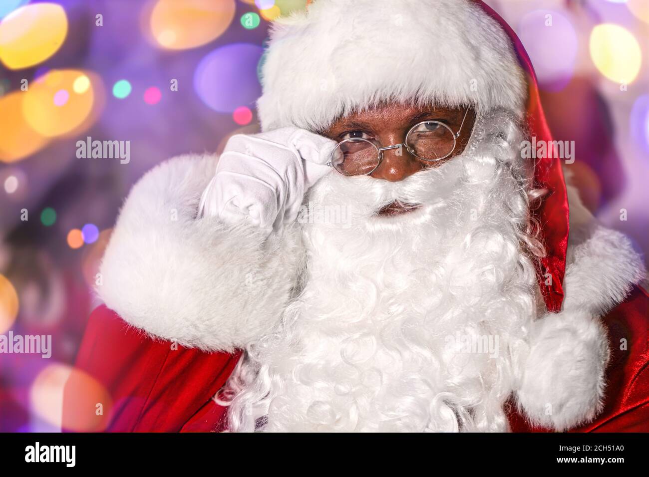 Babbo Natale afroamericano contro le luci offuscate Foto Stock