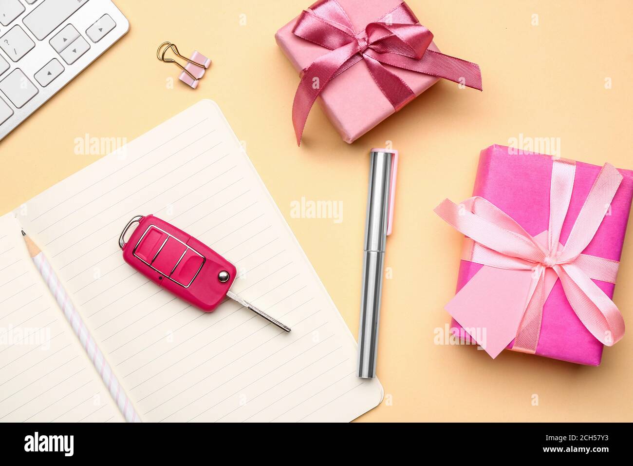 Confezioni regalo con chiave per auto e cancelleria sul tavolo Foto Stock