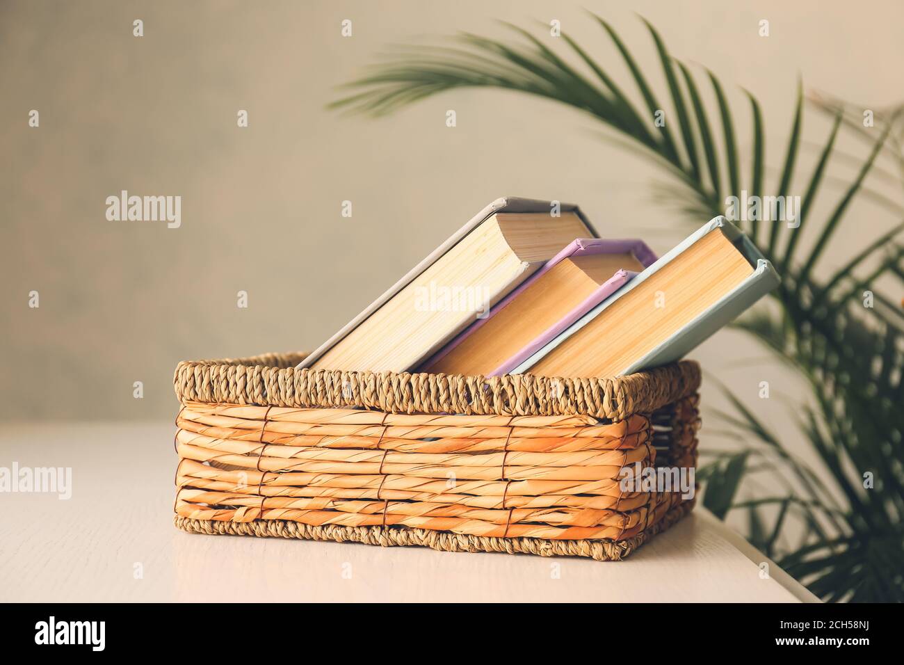 Cestino con libri sul tavolo in camera Foto stock - Alamy