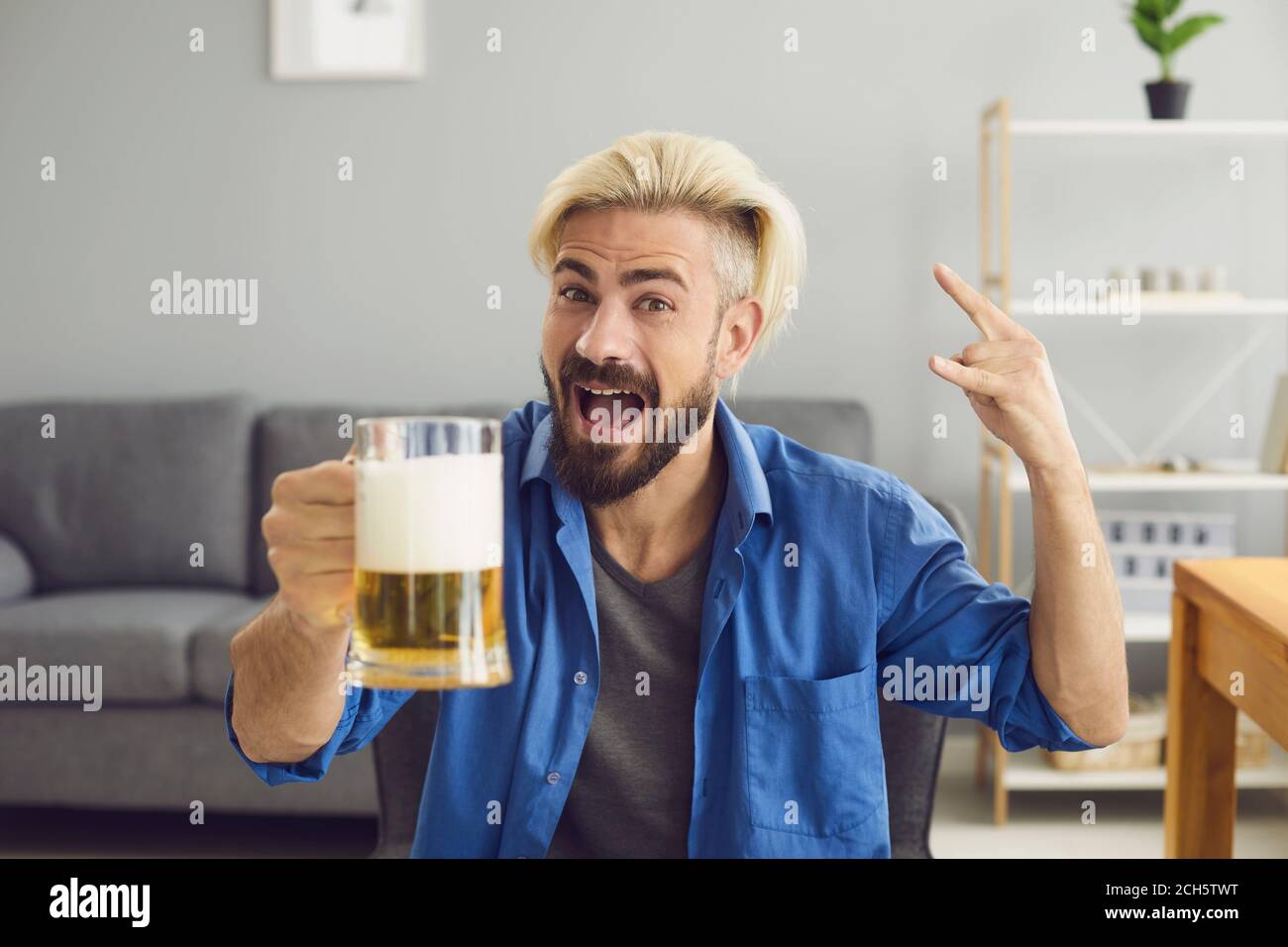 Tifoso con il team di supporto della birra a casa Foto Stock