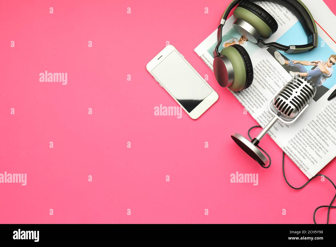 Cuffie con microfono, telefono cellulare e giornali su sfondo a colori Foto  stock - Alamy