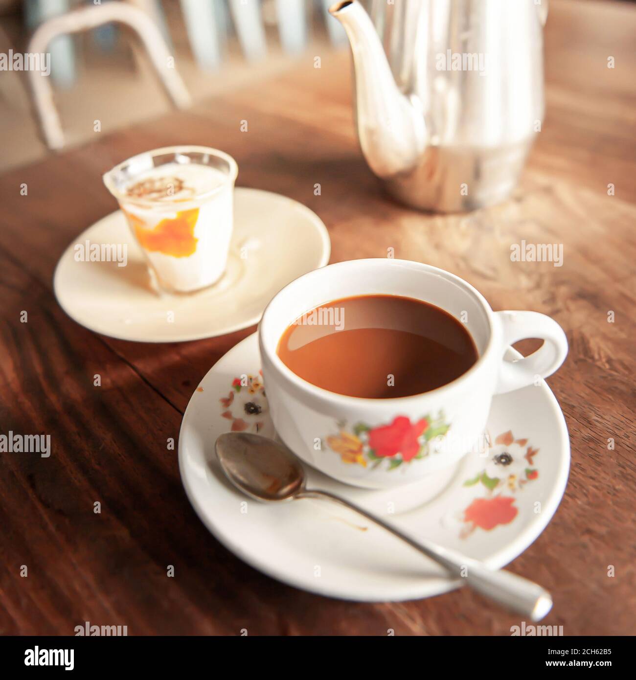 Rilassatevi in una vecchia caffetteria al mattino presto, vintage una tazza di caffè con uova sode e bollitore per il tè sono su vecchio tavolo di legno. Foto Stock