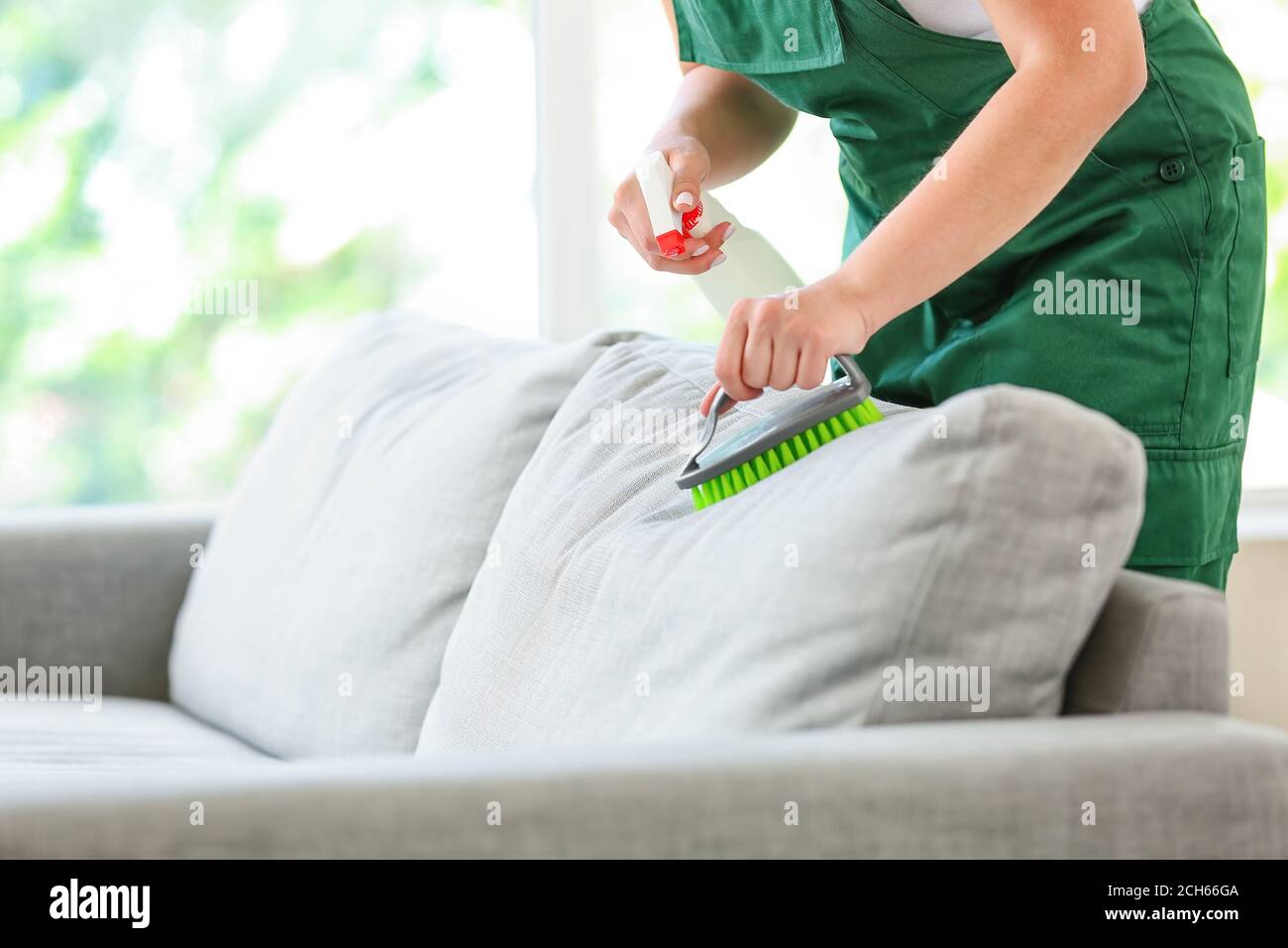 Il dipendente del pulitore a secco rimuove lo sporco dal divano in casa  Foto stock - Alamy