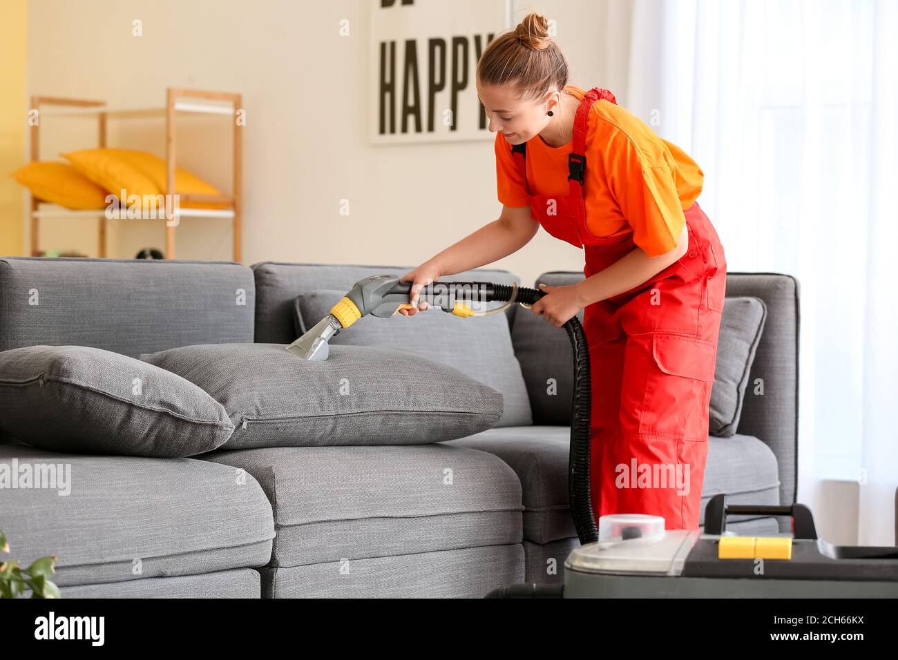 Il dipendente del pulitore a secco rimuove lo sporco dal divano in casa  Foto stock - Alamy
