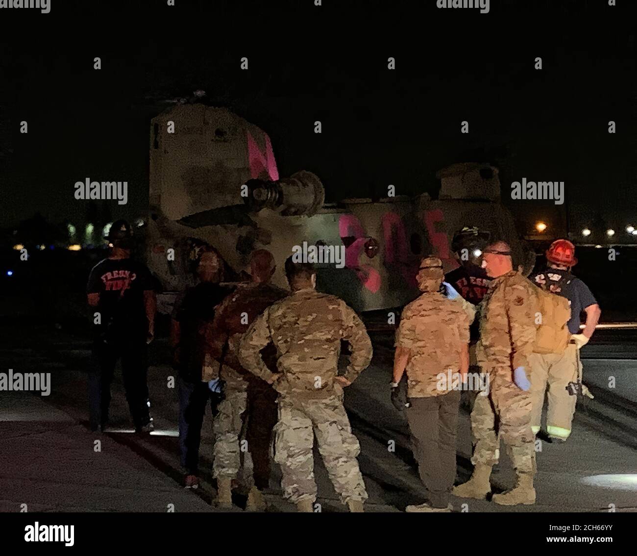 I guardiani nazionali della California, il dipartimento dei vigili del fuoco di Fresno e i servizi medici di emergenza della contea di Fresno attendono di dirigere gli evacuatori di un elicottero CH-47 Chinook della Brigata dell'aviazione di combattimento 40 dal fuoco del torrente alla linea di volo del 1106 del gruppo di manutenzione dell'aviazione di supporto a Fresno, California, 6 settembre 2020. Il Dipartimento militare della California ha evacuato oltre 200 persone lungo il bacino idrico di Mammoth Pool quando l'incendio del Creek è esploso in dimensioni. (STATI UNITI Air National Guard foto di Capt. Jason Sanchez) Foto Stock