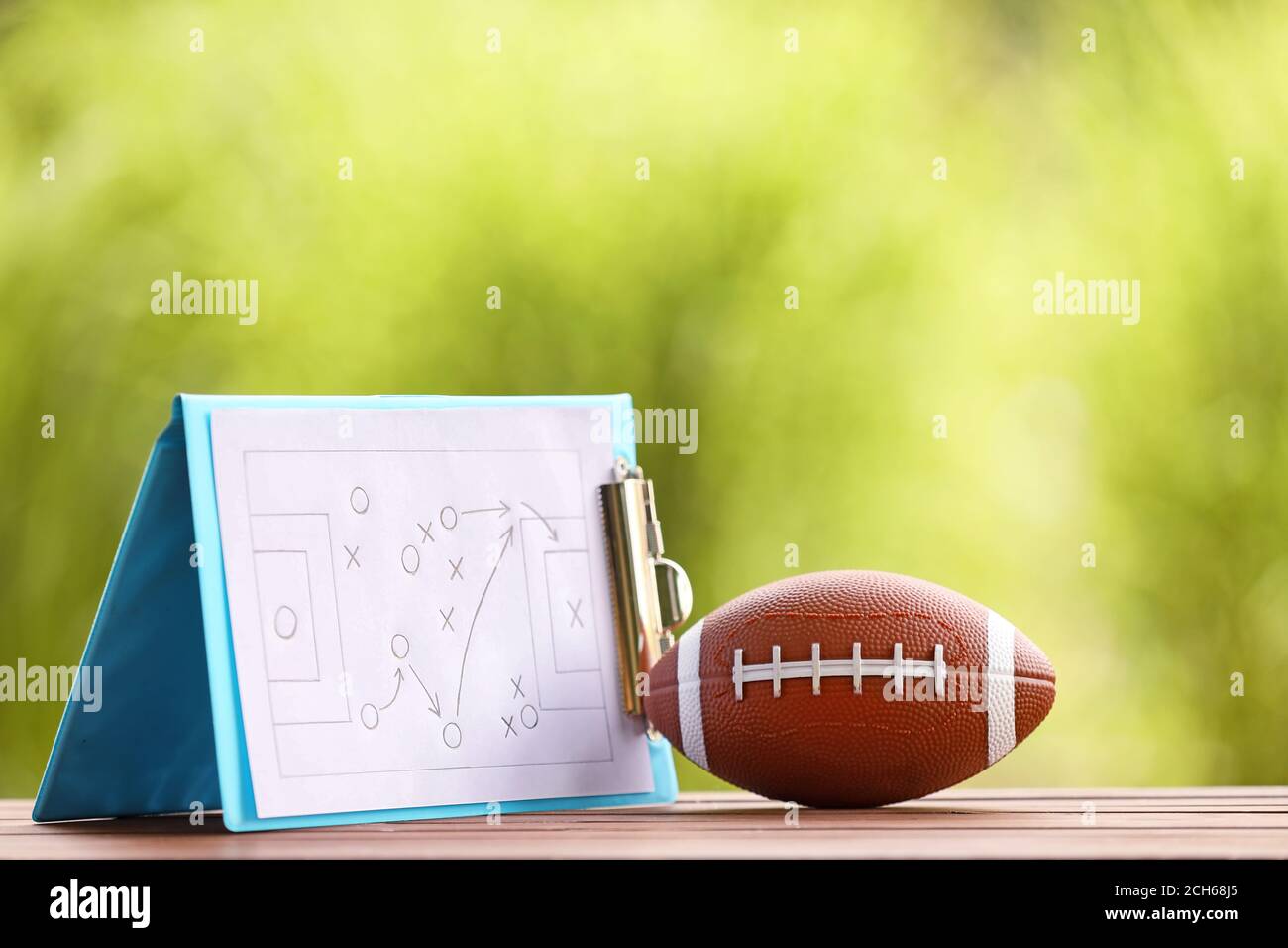 Palla di rugby con schema di gioco di calcio sul tavolo all'aperto Foto Stock