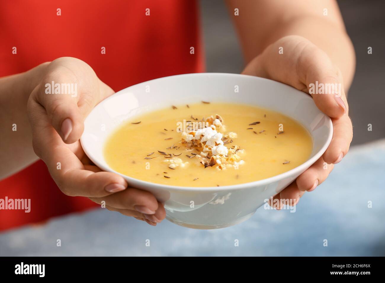 Donna con gustosa zuppa di popcorn in ciotola, primo piano Foto Stock