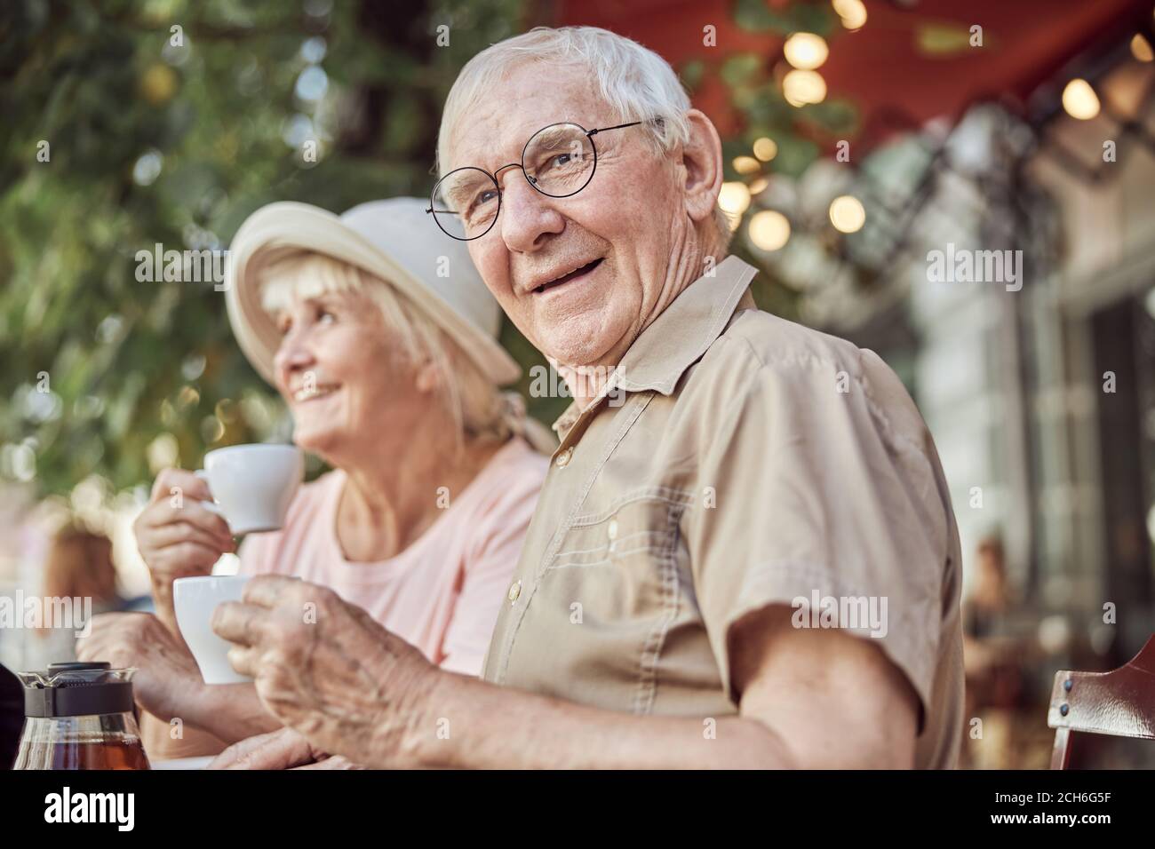 Moderna coppia anziana seduta in un caffè all'aperto Foto Stock