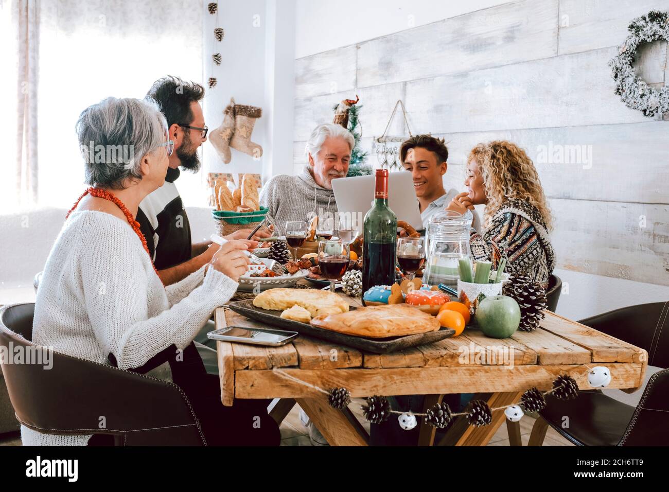 La famiglia gustatevi insieme il pranzo di natale a casa - il popolo caucasico buon divertimento in amicizia festeggiando le vacanze e vigilia - bianco scheda stile casa e legno Foto Stock