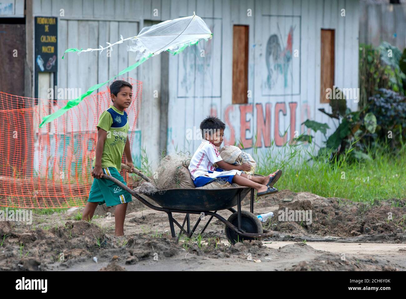 I ragazzi che volano un aquilone mentre cavalcano in un carrone della ruota  nella città di Amazon River dell'Indiana in Perù Foto stock - Alamy