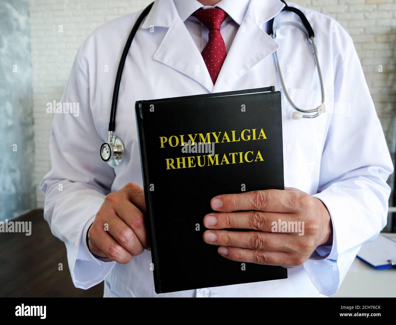 Il medico sta tenendo un libro sulla malattia di polimialgia reumatica. Foto Stock