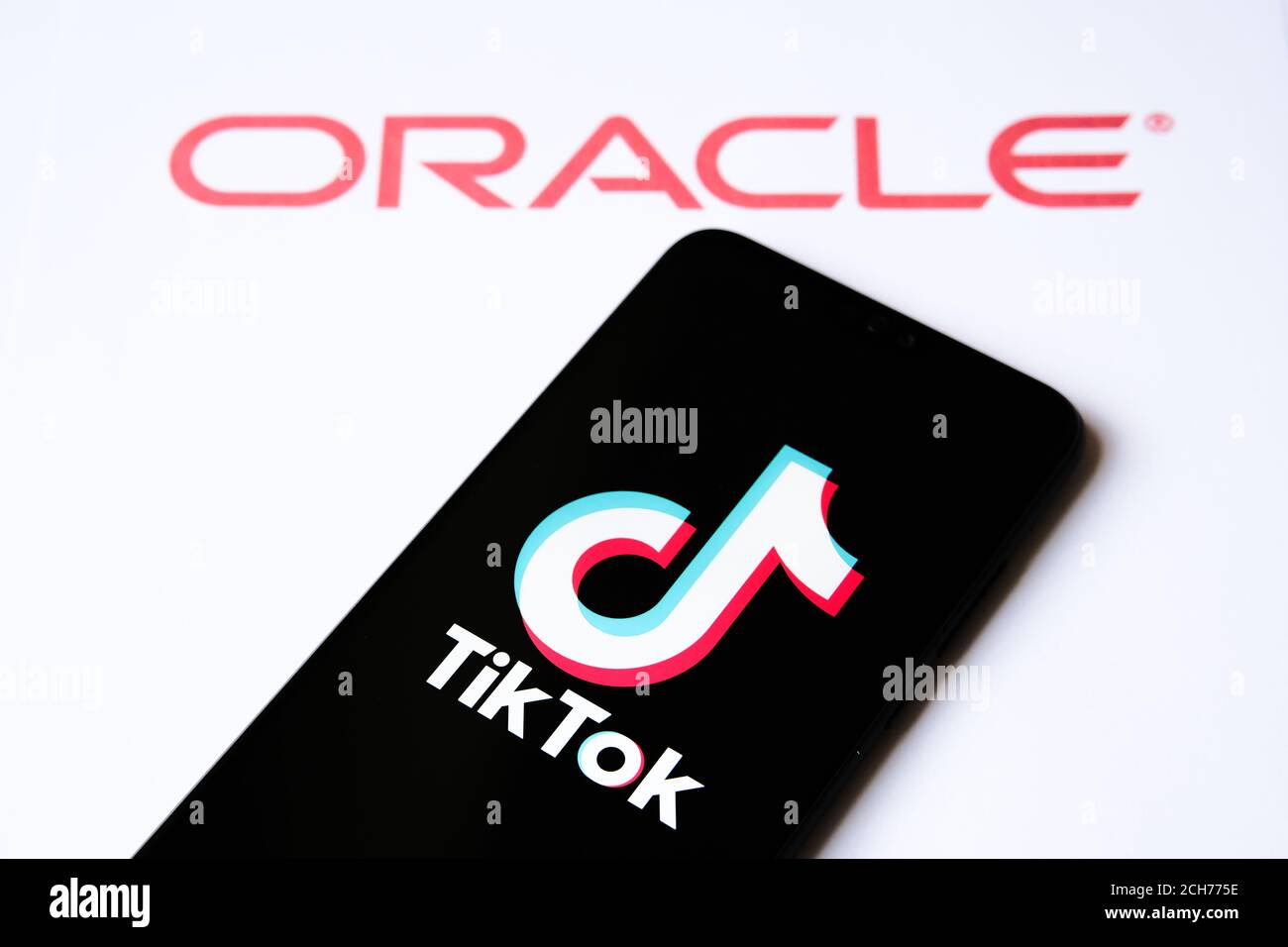 TikTok e la foto di concetto della partnership con Oracle. Logo TikTok sullo smartphone e logo aziendale Oracle sullo sfondo sfocato. Foto Stock