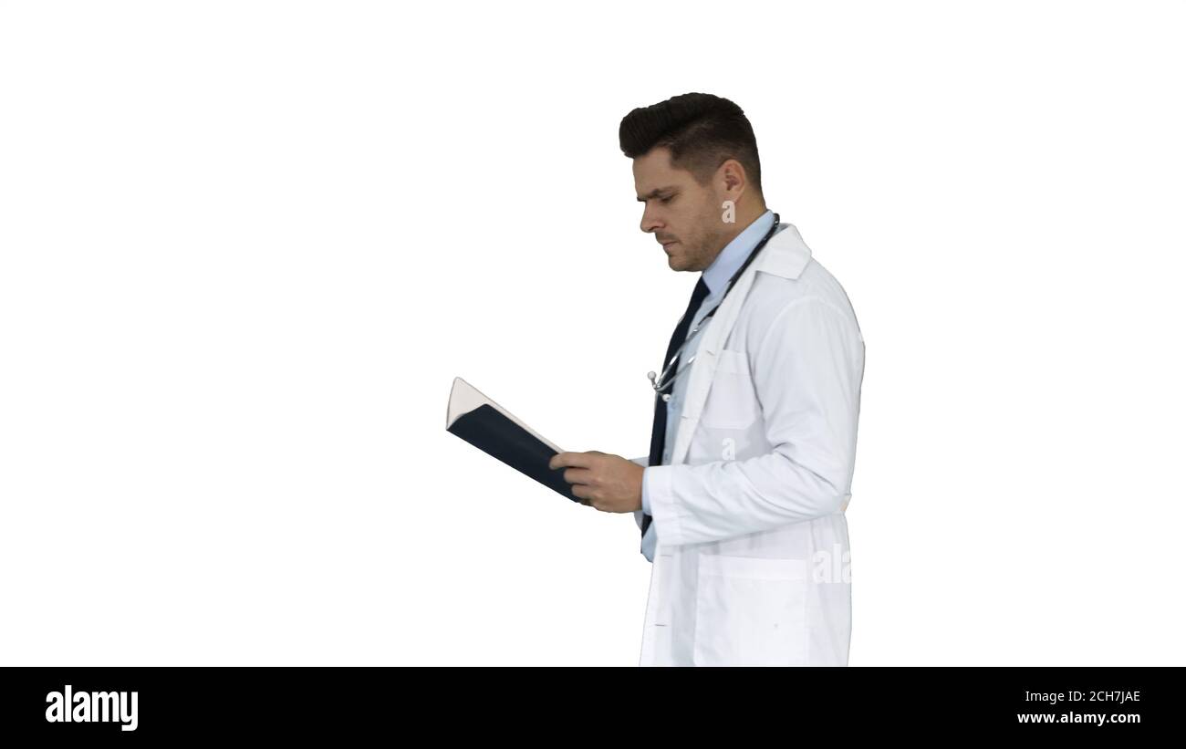 Medico concentrato che legge la documentazione mentre cammina su sfondo bianco. Foto Stock