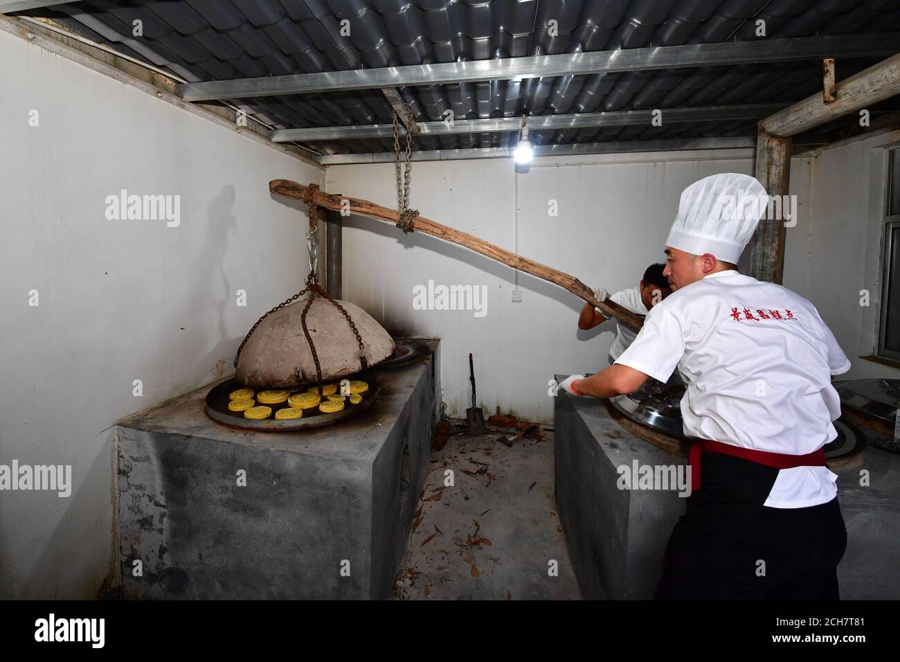 (200914) -- ZHENGZHOU, 14 settembre 2020 (Xinhua) -- Zhang Xu (R) frolla i mooncakes alla panetteria di mooncake Jingshengchang nella contea di Xiayi, Shangqiu, provincia centrale di Henan, 13 settembre 2020. All'età di 31 anni, Zhang Xu serve già come chef di Jingshengchang, una panetteria a base di mooncake Henan fondata nel 1860. I mooncakes prodotti a Jingshengchang sono caratterizzati dalle loro croste croccanti e dalle generose imbottiture, insieme ad una meticolosa serie di abilità da forno che Zhang aveva cominciato ad imparare fin dalla laurea in alta scuola nel 2007. "Le nostre abilità da forno sono un grande tesoro", dice Zhang. "Farò il mio Foto Stock