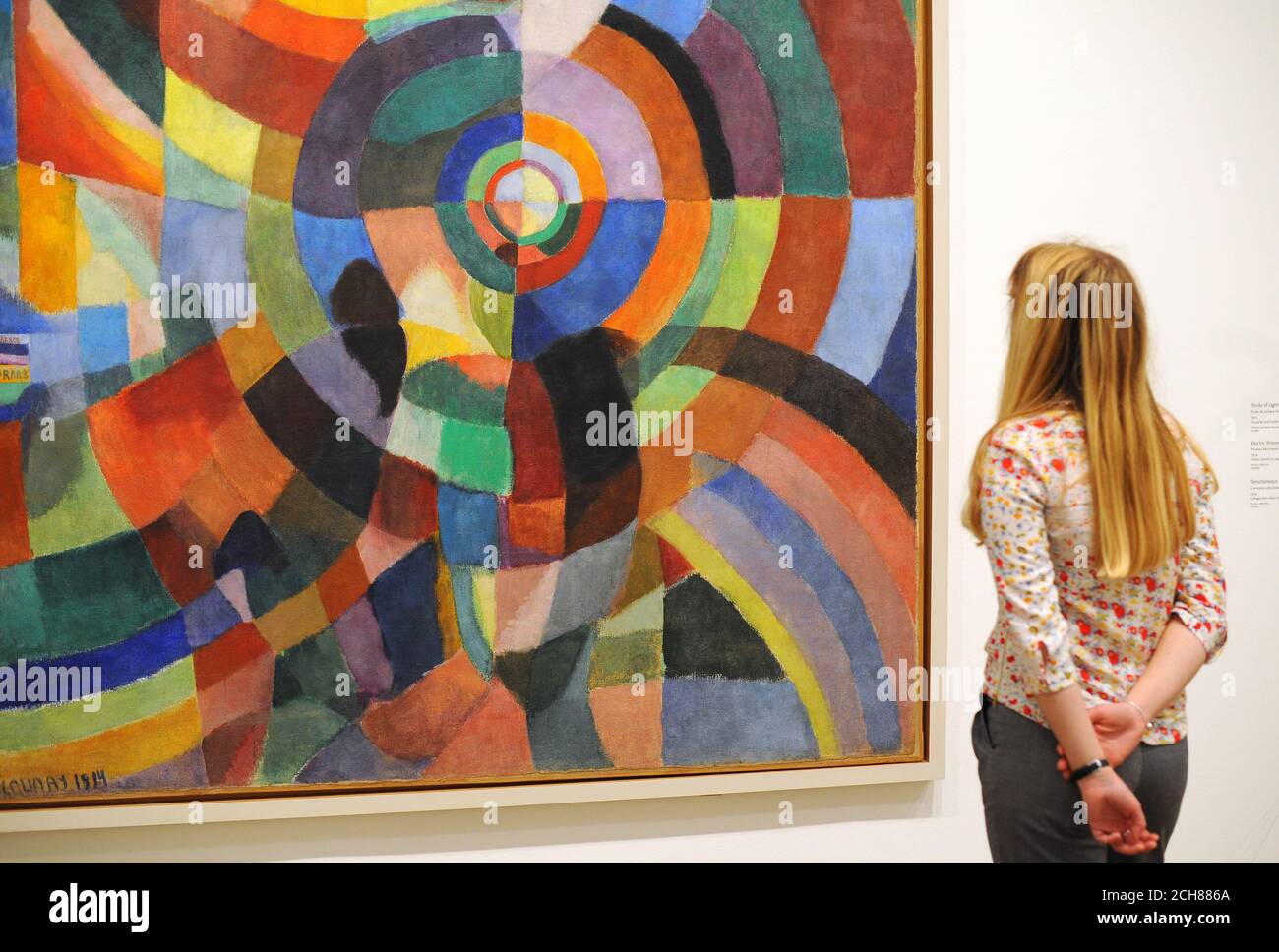 Un dipendente di Tate Modern guarda ai prismi elettrici 1914, dell'artista Sonia Delaunay, che fa parte dell'EY Exhibition: Sonia Delaunay al Tate Modern di Londra. Foto Stock