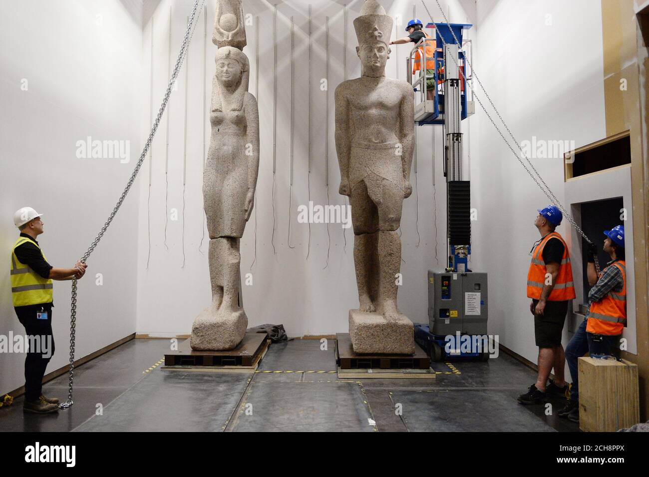 Il personale del British Museum lavora per installare due colossali statue di un re e di una regina, forse del regno di Tolomeo II (283-246 a.C.), ma più tardi riarved. Il re è alto 5 m e la regina si erge a 4,9 m. Entrambi sono realizzati in granito rosa e sono stati scoperti da Franck Goddio sul sito di Thonis-Heracleion e faranno parte della mostra BP città sunken: I mondi perduti dell'Egitto che si svolge dal 19 maggio al 27 novembre 2016 al British Museum di Londra. Foto Stock