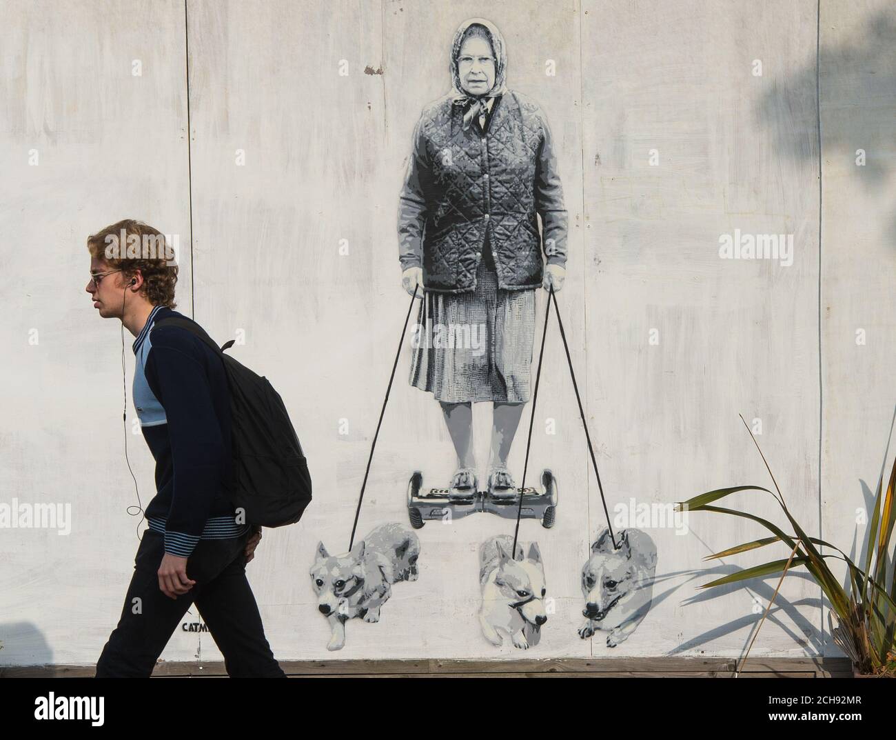 Un uomo passa un nuovo murale che mostra la regina Elisabetta II, dal catman dell'artista di strada, a East Dulwich, Londra. Foto Stock