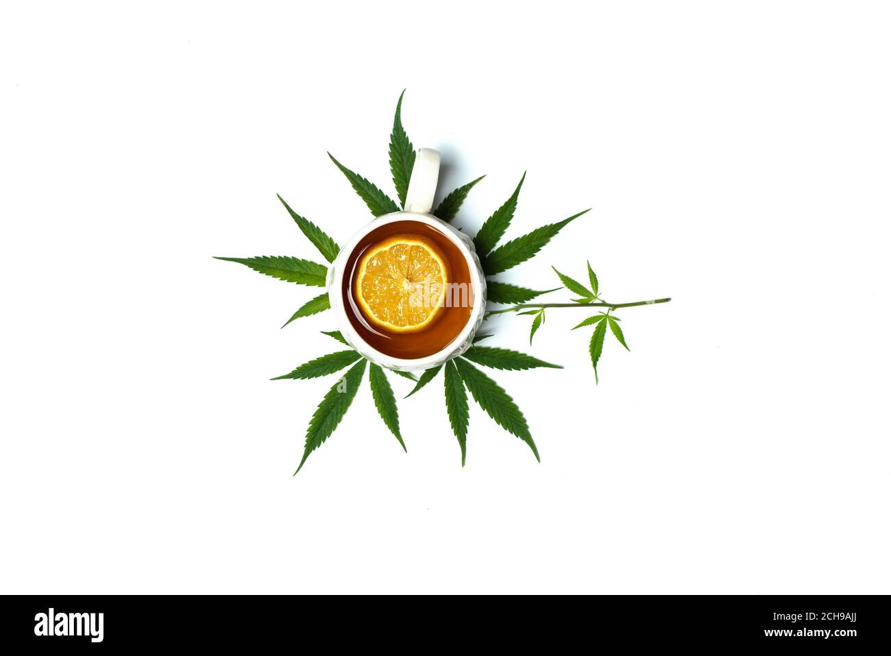 Tazza di tè infuso di marijuana in una tazza sopra di foglie di marijuana vista dall'alto isolata con spazio di copia Foto Stock