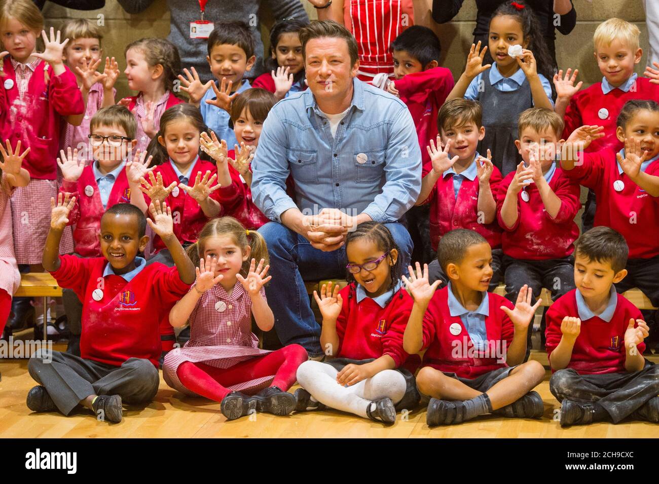 Jamie Oliver con gli alunni della Kings Cross Academy di Londra, durante una visita alla Giornata della Rivoluzione alimentare, parte della campagna della Rivoluzione alimentare che mira ad affrontare i problemi della nutrizione infantile. Foto Stock