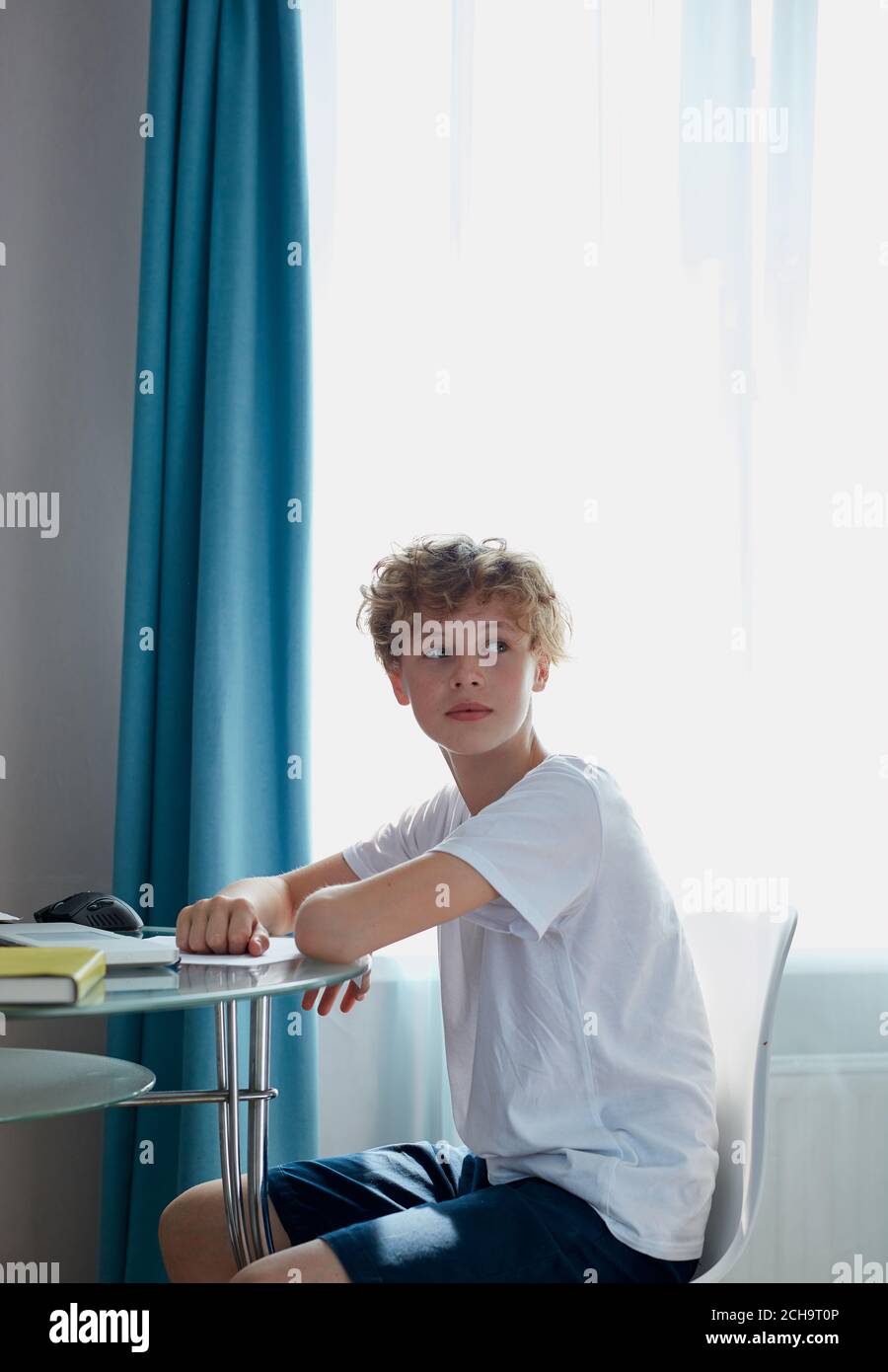 giovane caucasico rosso ragazzo hanno riposo a casa, ha un po 'di tempo libero dopo lo studio, la scuola. si siede a guardare via, prendere una pausa. a casa Foto Stock