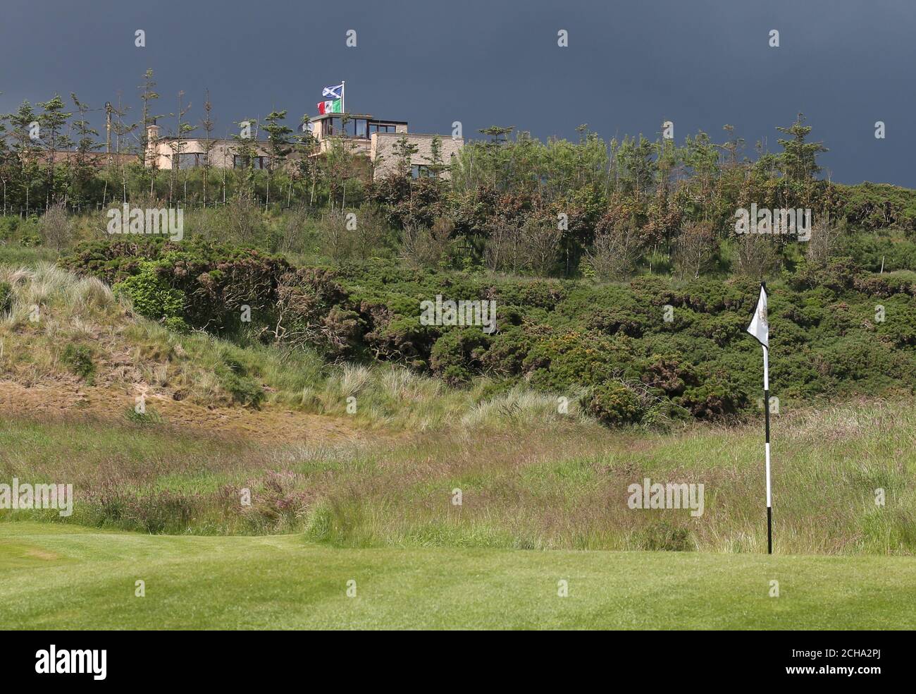 Una bandiera messicana flutters nel vento da una casa Confinante con Trump International Golf Links a Balmeddie Foto Stock